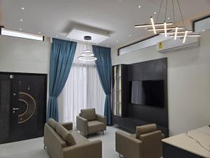 a living room with chairs and a flat screen tv at Nana's Villa in Danfa