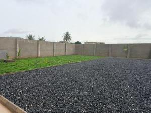 a black gravel driveway next to a fence at Nana's Villa in Danfa