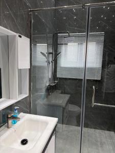 a bathroom with a shower and a sink and a toilet at Nana's Villa in Danfa +3 photos