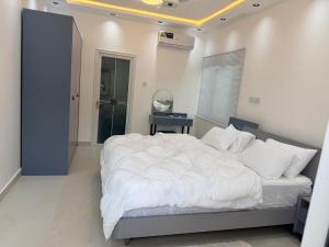 a bedroom with a large bed with white sheets at Nana's Villa in Danfa