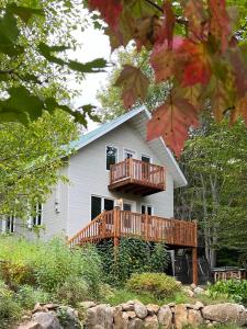 a house with a deck and a balcony at Rustic Villa Country Getaway in Saint-Gabriel-de-Brandon