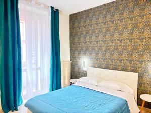 a bedroom with a bed and a wall with blue curtains at Pasubio House appartamento in Campobasso