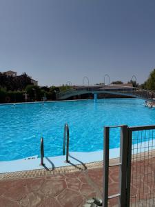 a large blue swimming pool with a bridge in the background at Casa Limón in Bodonal de la Sierra