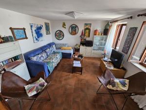 a living room with a blue couch and chairs at Casa Mersino in Lindar