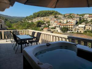 a hot tub on a balcony with a table and chairs at Apartment Mladinić Muse in Pučišća