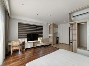 a bedroom with a bed and a desk and a television at Zen Central Hotel Bac Giang in Bắc Giang