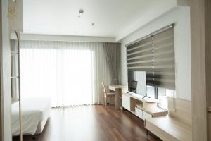a hotel room with a bed and a desk and a bedroom at Zen Central Hotel Bac Giang in Bắc Giang