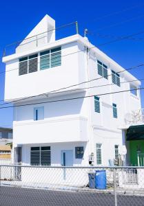 a white building with a fence in front of it at Bright & Comfortable 2BR San Juan Getaway in San Juan