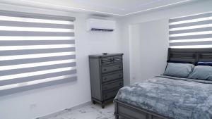 a bedroom with a bed and a dresser in it at Bright & Comfortable 2BR San Juan Getaway in San Juan