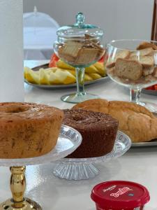 a table with different types of cakes and other desserts at Pousada Shopping do Sono in Jaciara