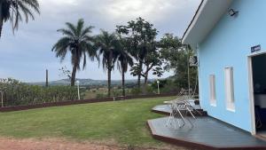 a porch of a house with chairs and palm trees at Pousada Shopping do Sono in Jaciara +13 photos