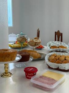 a table topped with cakes and other food items at Pousada Shopping do Sono in Jaciara