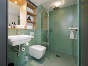 a bathroom with a toilet and a sink and a shower at smartments München Parkstadt Schwabing in Munich +32 photos
