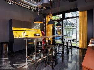 a kitchen with a bar with stools at smartments München Parkstadt Schwabing in Munich