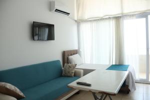 a living room with a blue couch and a table at Hakan Pension in Merdivenlikuyu