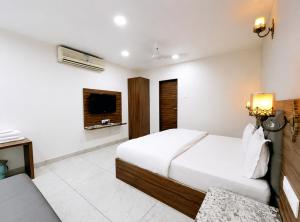 a hotel room with a bed and a television at Hotel Aradhana In Mount Abu in Mount Ābu +17 photos