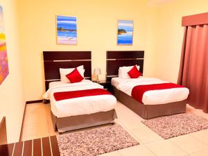 a bedroom with two beds with red pillows at Ruru Tower Luxury Apartment in Juffair +25 photos