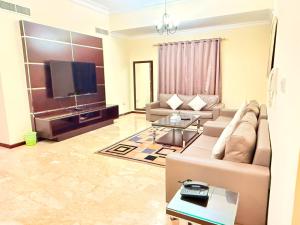 a living room with a couch and a flat screen tv at Ruru Tower Luxury Apartment in Juffair