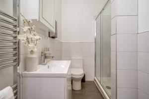 a white bathroom with a toilet and a sink at Wakefield Town House Accomodation in Wakefield
