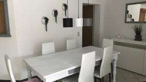 a white dining room with a white table and chairs at Blue-House Mosel in Piesport +1 photo