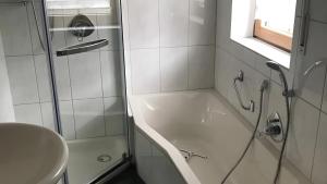 a bathroom with a shower and a sink and a tub at Blue-House Mosel in Piesport