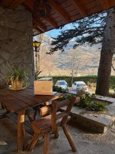 a wooden picnic table with a laptop computer on it at Hotel Vallibierna in Benasque