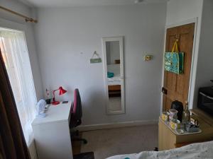 a room with a bedroom with a desk and a mirror at BEE KIND available with shared bathroom in Glastonbury
