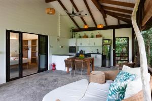 a kitchen and living room with a couch and a table at La Pointe Beach Huts in Praslin