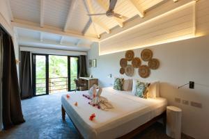 a bedroom with a bed in a room at La Pointe Beach Huts in Praslin