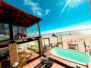 a house with a swimming pool and a beach at Pousada e restaurante casa dos ventos in Icapuí