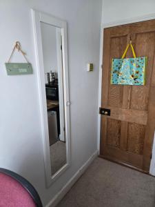 a door with a mirror next to a room at BEE KIND available with shared bathroom in Glastonbury +2 photos