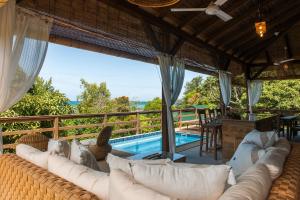 a living room with a couch and a swimming pool at La Pointe Beach Huts in Praslin