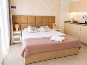 a bedroom with a large bed with two towels on it at Apartamenty Sunny Stay Jastarnia in Jastarnia