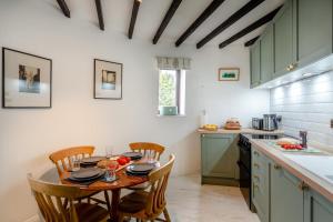 a kitchen with a table and chairs and a kitchen with green cabinets at 3 Bed in Kirkbymoorside oc-y100 in Kirkbymoorside