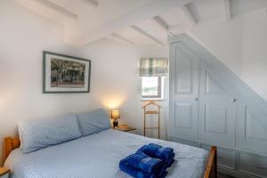 a bedroom with a bed with a blue blanket on it at 3 Bed in Kirkbymoorside oc-y100 in Kirkbymoorside