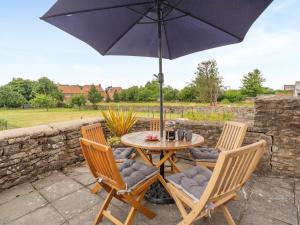 a table and chairs with an umbrella on a patio at 3 Bed in Kirkbymoorside oc-y100 in Kirkbymoorside