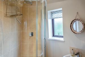 a bathroom with a shower and a sink and a mirror at 3 Bed in Kirkbymoorside oc-y100 in Kirkbymoorside +17 photos
