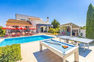 a pool with two ping pong tables in front of a house at Villa Bella by Villa Plus in Svetvinčenat