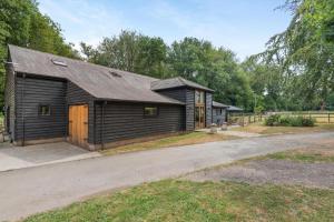 a small wooden house with a driveway at 4 Bed in Ewhurst Green oc-w31032 in Hurst Green