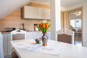 wazon z kwiatami na stole w kuchni w obiekcie Guesthouse Viktorija Flat - Deluxe Apartment w mieście Otočac