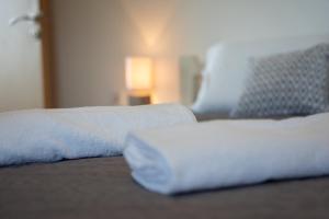 zbliżenie łóżka z białymi prześcieradłami i poduszkami w obiekcie Guesthouse Viktorija Flat - Deluxe Apartment w mieście Otočac +3 zdjęcia