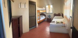 a small room with two bunk beds and a hallway at Auto Hostal Jaramisol in Jaramijó