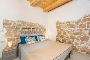 ein Schlafzimmer mit einem Bett vor einer Steinwand in der Unterkunft Tra Cale e Rioni in Baunei