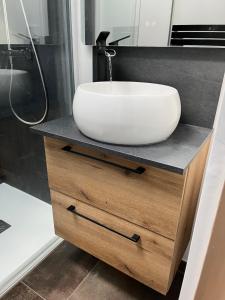 a bathroom with a white sink on a counter at L'Escale de Gaston in Sainte-Florence