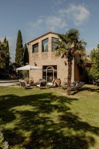 a house with a palm tree in the yard at Agriturismo Quarantallina in Buonconvento