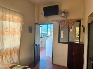 a room with a door and a television on the wall at Auto Hostal Jaramisol in Jaramijó