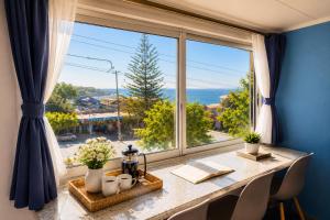 a dining room with a table and a large window at Hostal Boutique F in El Quisco