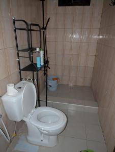 a bathroom with a white toilet in a room at Eden Vista Stays in Dar es Salaam