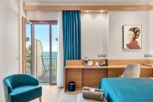 ein Schlafzimmer mit einem blauen Bett und einem Stuhl in der Unterkunft Hotel Porto Roca in Monterosso al Mare + 66 Fotos