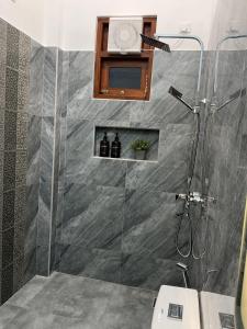 a bathroom with a shower with a glass door at The Oak Residence in Ragama